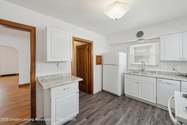 kitchen with hardwood / wood-style flooring, sink, white cabinets, and white appliances