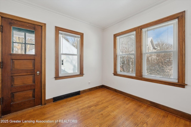 entryway with crown molding and light hardwood / wood-style flooring