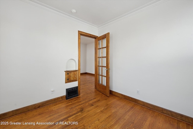 spare room with hardwood / wood-style flooring and ornamental molding