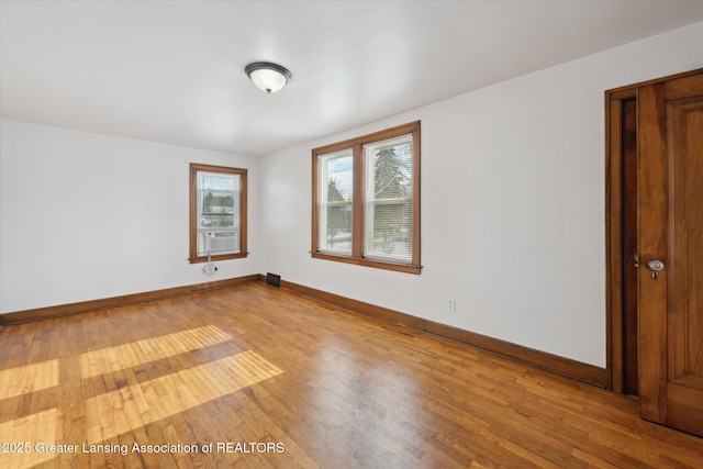 unfurnished room with cooling unit and light hardwood / wood-style floors