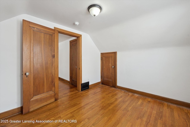 bonus room featuring lofted ceiling and hardwood / wood-style flooring