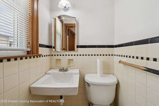 bathroom featuring tile walls, sink, and toilet