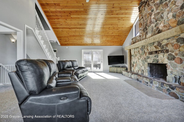 carpeted living room with wood ceiling, a stone fireplace, high vaulted ceiling, and french doors