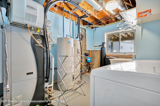 clothes washing area featuring heating unit, sink, washer / dryer, and gas water heater