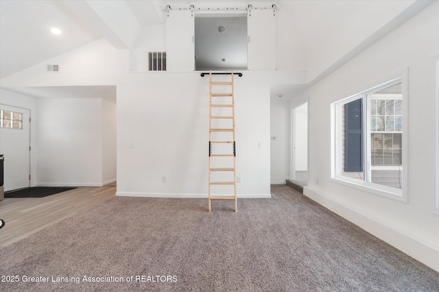 unfurnished living room with carpet floors and vaulted ceiling with beams