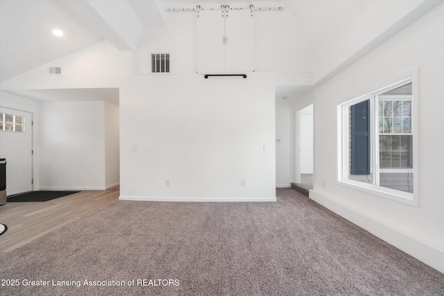 unfurnished living room with carpet floors, high vaulted ceiling, and beamed ceiling