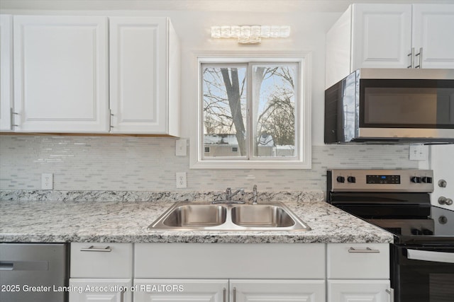 kitchen with white cabinetry, stainless steel appliances, sink, and decorative backsplash