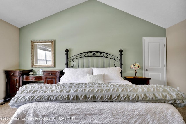 bedroom with carpet floors and vaulted ceiling