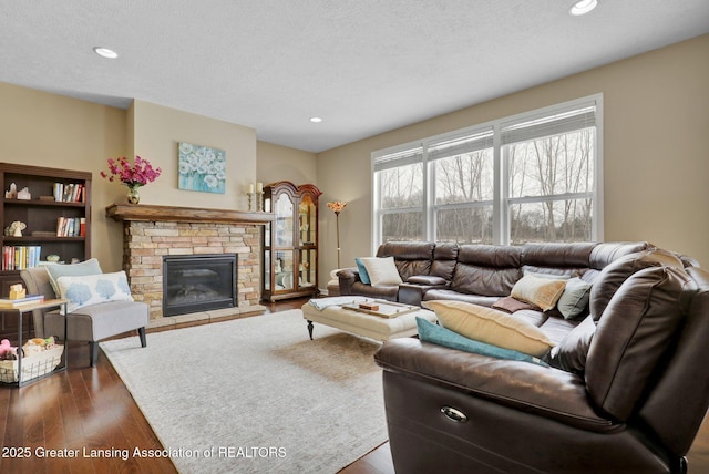 living room featuring dark hardwood / wood-style floors, a textured ceiling, and a fireplace