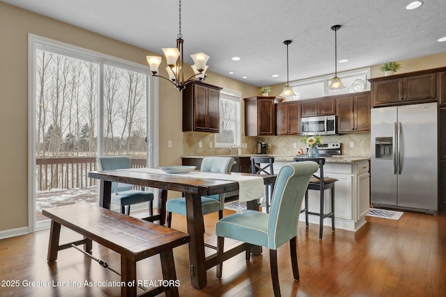 dining room featuring hardwood / wood-style flooring, a chandelier, and a textured ceiling