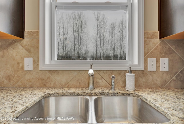 details featuring light stone countertops and sink