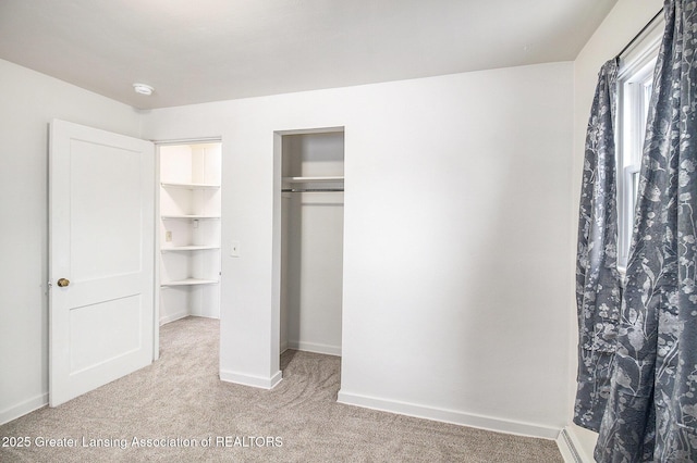 unfurnished bedroom with light carpet and a closet