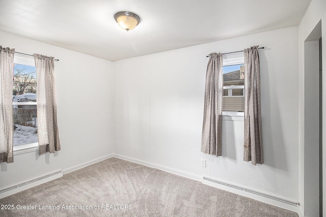 carpeted spare room with a baseboard radiator