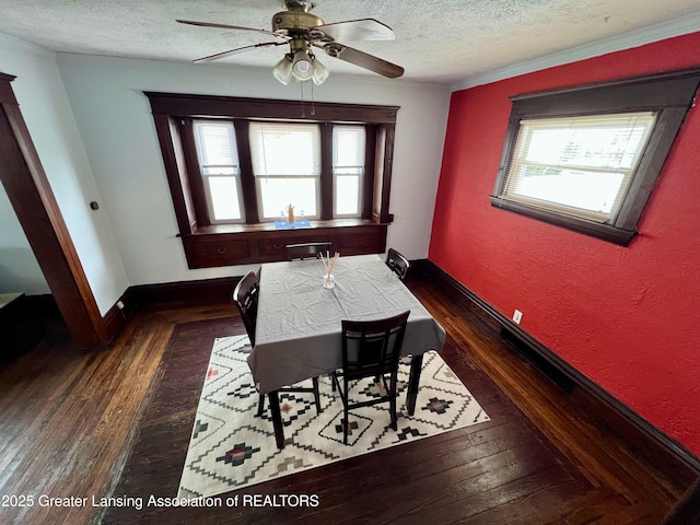 dining area with dark hardwood / wood-style flooring, a wealth of natural light, and a textured ceiling