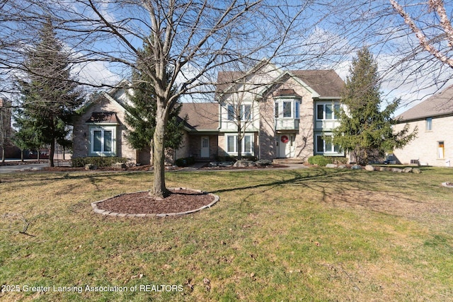 view of front of home with a shingled roof and a front yard