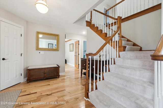 staircase with baseboards and wood finished floors