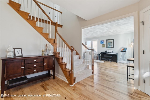 stairs featuring wood finished floors and baseboards