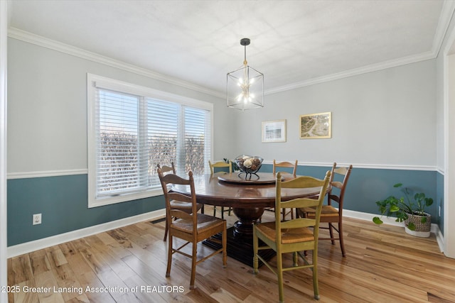 dining room with baseboards, a notable chandelier, light wood-style flooring, and crown molding