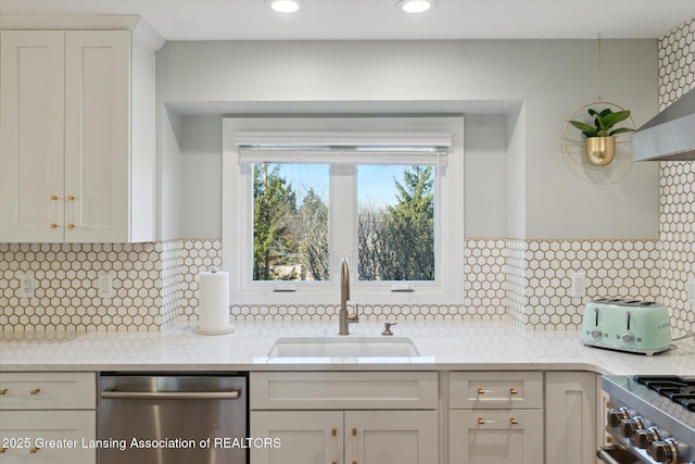 kitchen with tasteful backsplash, white cabinetry, stainless steel appliances, and a sink