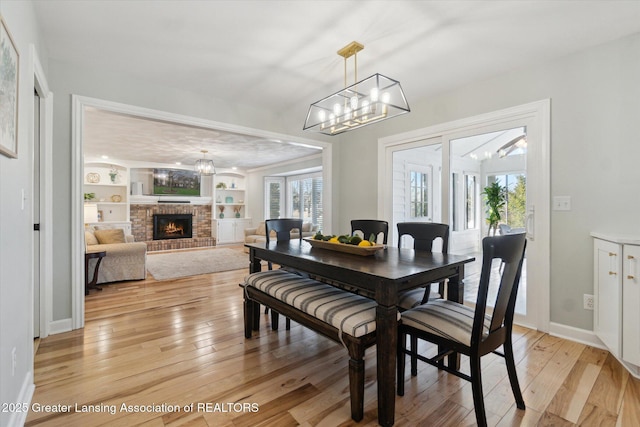 dining space with plenty of natural light, light wood finished floors, and a chandelier