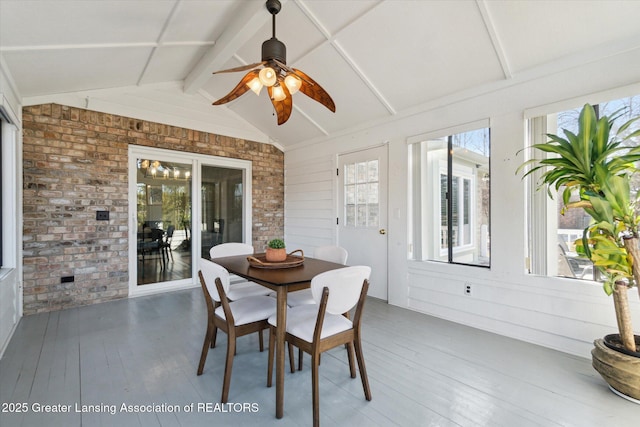 sunroom / solarium featuring lofted ceiling with beams and a ceiling fan