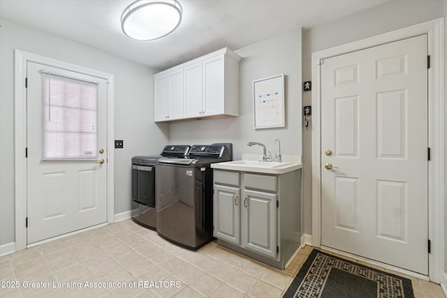 washroom with washer and dryer, a sink, cabinet space, light tile patterned flooring, and baseboards