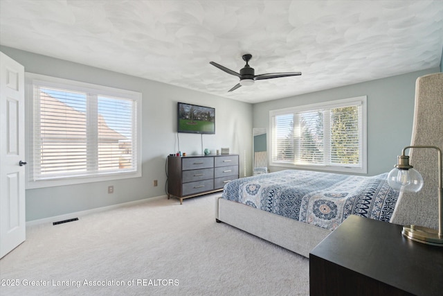 carpeted bedroom featuring visible vents, baseboards, and a ceiling fan