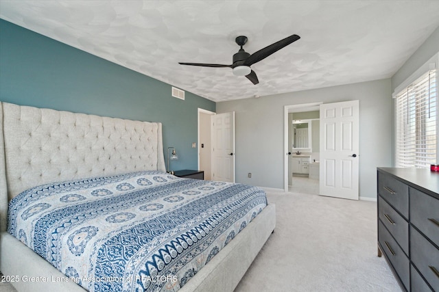 bedroom with a ceiling fan, baseboards, visible vents, light carpet, and connected bathroom