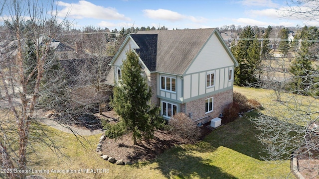 exterior space with a front yard, board and batten siding, and a shingled roof