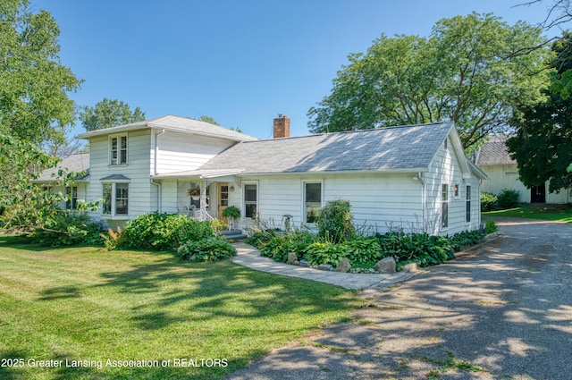 view of front of property with a chimney and a front yard