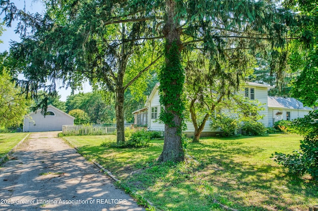 view of front of home featuring a front lawn, fence, and aphalt driveway