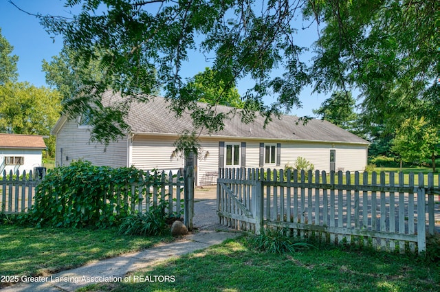 view of front of property featuring fence private yard, a front lawn, and roof with shingles