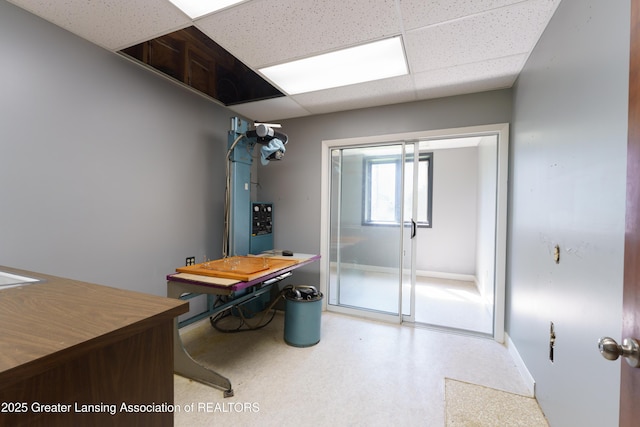 bathroom with a paneled ceiling and baseboards