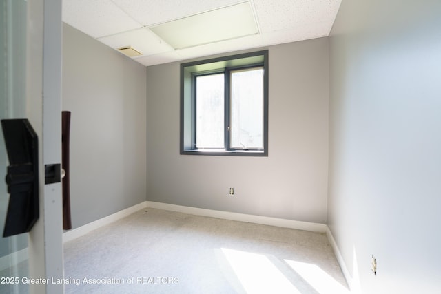 unfurnished room with a paneled ceiling, visible vents, and baseboards