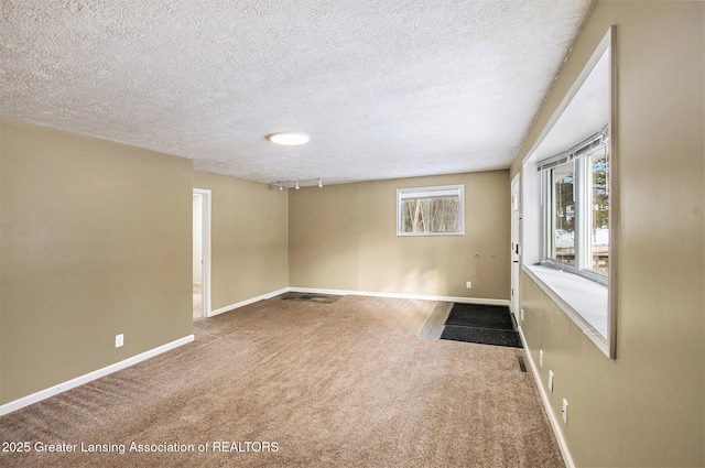 spare room featuring a textured ceiling and carpet flooring