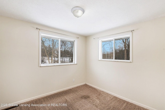 carpeted empty room featuring a textured ceiling