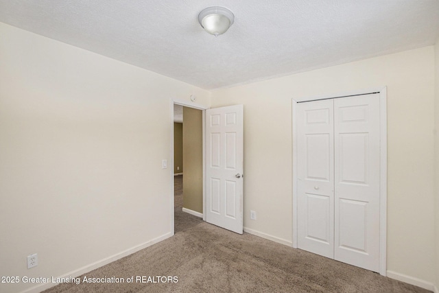 unfurnished bedroom featuring a closet, a textured ceiling, and carpet