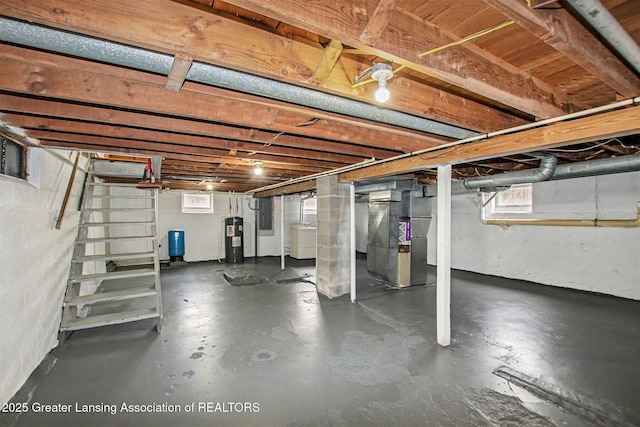 basement featuring heating unit, washer / clothes dryer, electric panel, and electric water heater