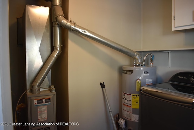 utility room with gas water heater and washer / dryer