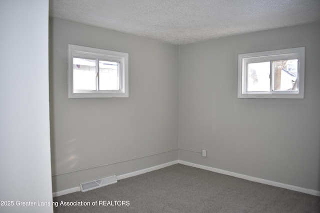 carpeted spare room with a textured ceiling