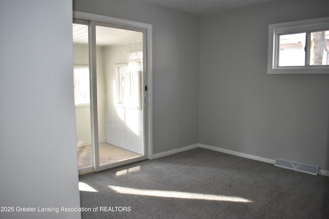 carpeted spare room featuring a textured ceiling