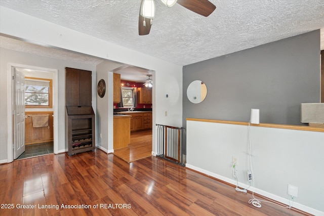 interior space featuring dark hardwood / wood-style floors, sink, a textured ceiling, and ceiling fan