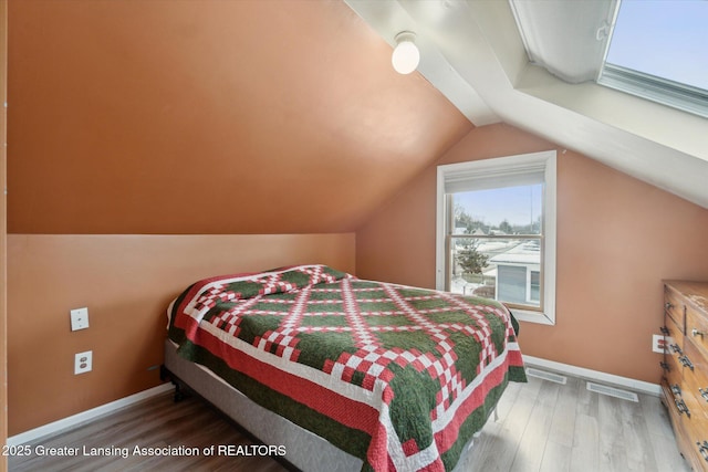 bedroom with lofted ceiling and hardwood / wood-style floors