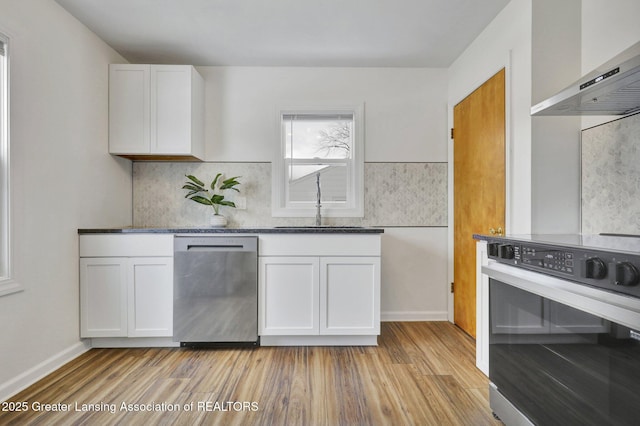 kitchen with white cabinetry, stove, wall chimney exhaust hood, and dishwasher