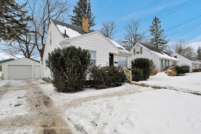 view of snowy exterior with a garage and an outdoor structure