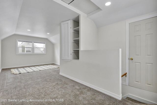 additional living space with light carpet and vaulted ceiling