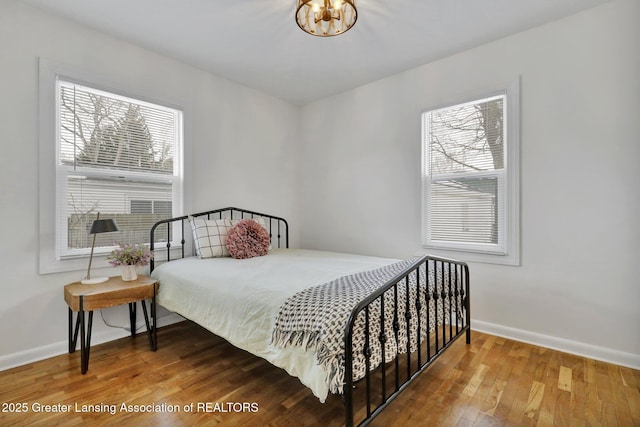 bedroom with wood-type flooring and multiple windows