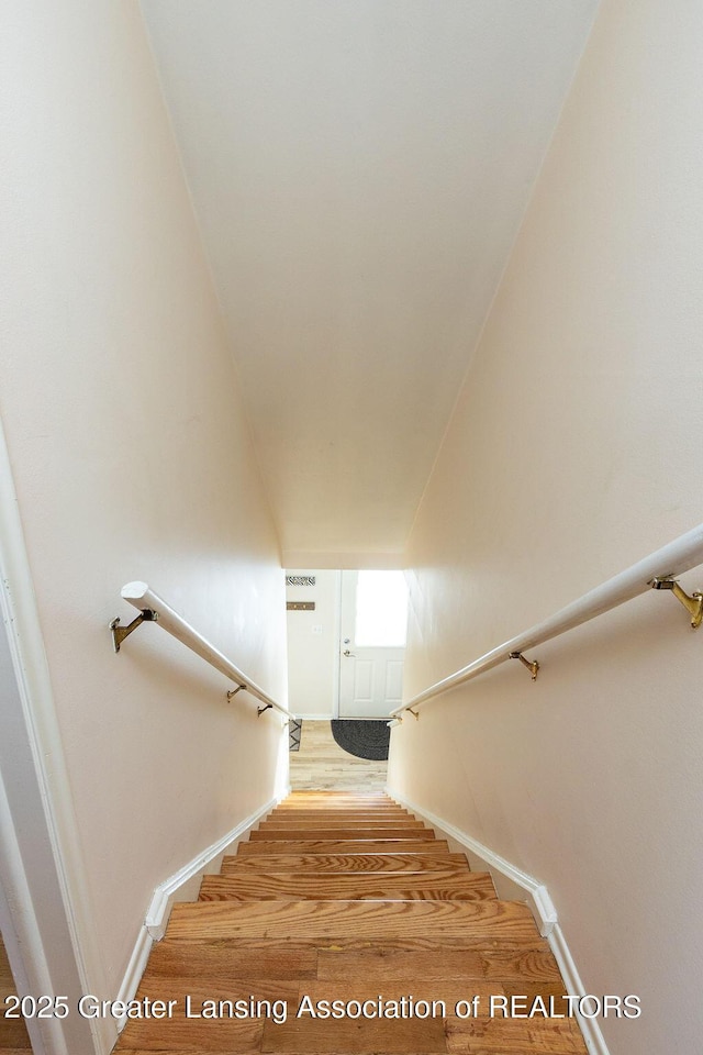 staircase with hardwood / wood-style floors