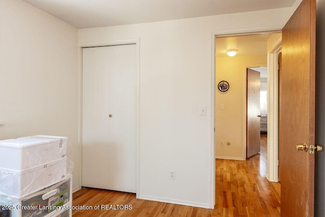 unfurnished bedroom featuring a closet and light hardwood / wood-style flooring