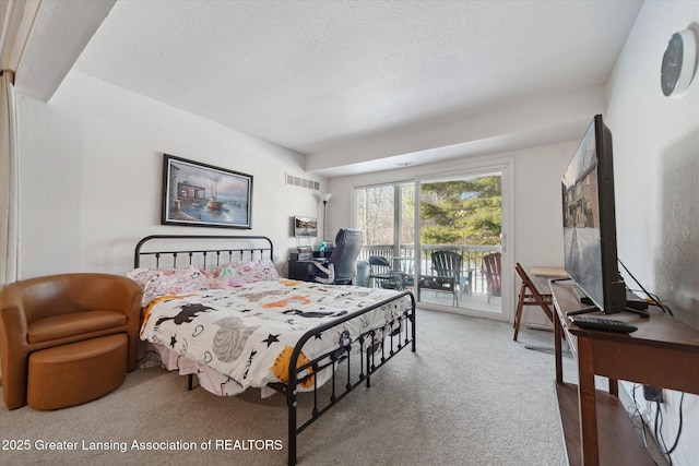 bedroom featuring carpet flooring, access to exterior, and a textured ceiling